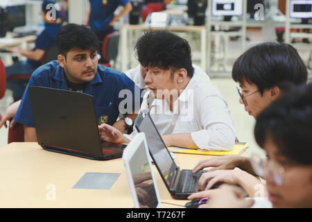 Group of Asian computer engineering students working together to complete a computer programming project at an University Stock Photo
