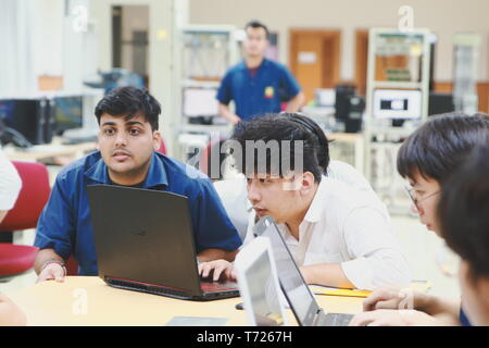 Group of Asian computer engineering students working together to complete a computer programming project at an University Stock Photo