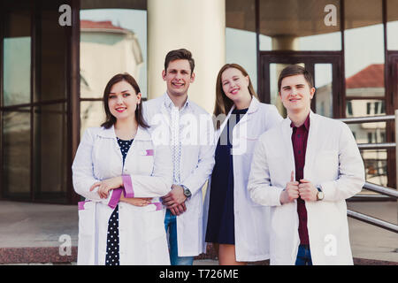 Education and health. general practitioner. A group of smart medical students in college. Friends interns on the background of the hospital. Teamwork  Stock Photo