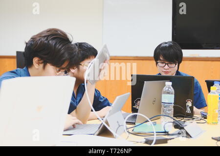 Groups of Thai Computer Engineering students at Assumption University (ABAC) Working on their coding project in a classroom Stock Photo