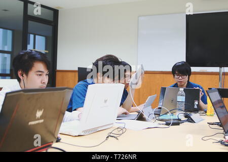 Groups of Thai Computer Engineering students at Assumption University (ABAC) Working on their coding project in a classroom Stock Photo