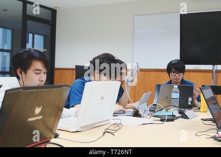 Groups of Thai Computer Engineering students at Assumption University (ABAC) Working on their coding project in a classroom Stock Photo