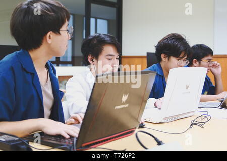Groups of Thai Computer Engineering students at Assumption University (ABAC) Working on their coding project in a classroom Stock Photo