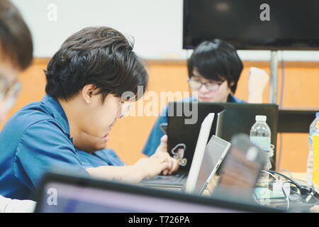Portrait of a Computer Engineering student at Assumption University working on his coding project on his laptop Stock Photo