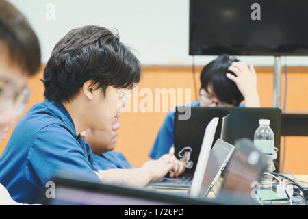 Portrait of a Computer Engineering student at Assumption University working on his coding project on his laptop Stock Photo