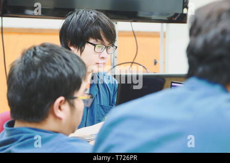 Portrait of a Computer Engineering student at Assumption University working on his coding project on his laptop Stock Photo