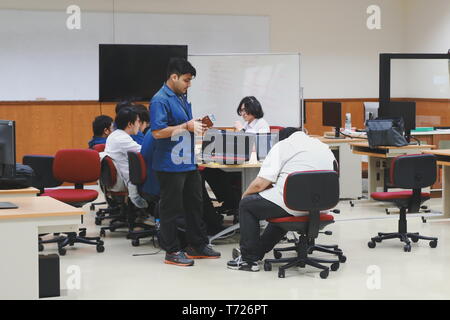 Groups of Thai Computer Engineering students at Assumption University (ABAC) discussing in a meeting room about their computer programming project Stock Photo
