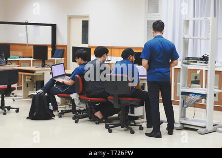 Groups of Thai Computer Engineering students at Assumption University (ABAC) discussing in a meeting room about their computer programming project Stock Photo
