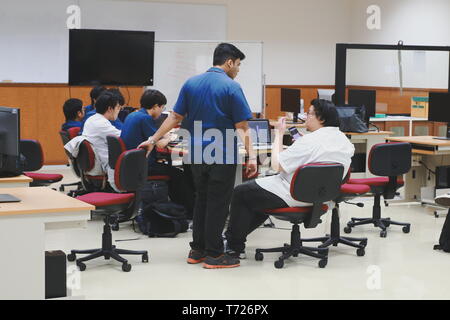 Groups of Thai Computer Engineering students at Assumption University (ABAC) discussing in a meeting room about their computer programming project Stock Photo