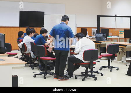 Groups of Thai Computer Engineering students at Assumption University (ABAC) discussing in a meeting room about their computer programming project Stock Photo