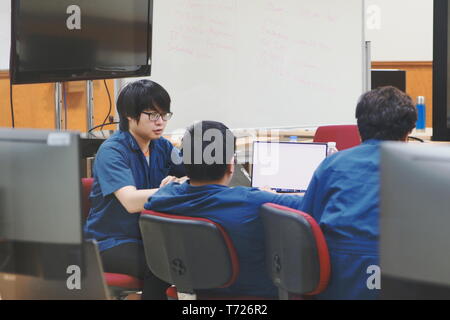Groups of Thai Computer Engineering students at Assumption University (ABAC) discussing in a meeting room about their computer programming project Stock Photo