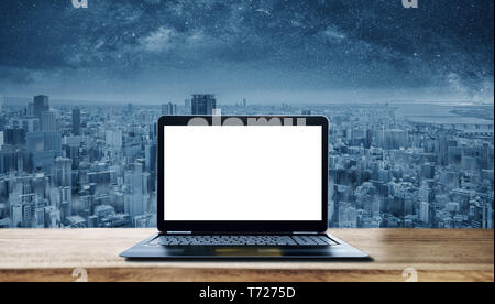 Laptop Computer Background. Computer laptop blank white screen on wooden desk and futuristic city background Stock Photo