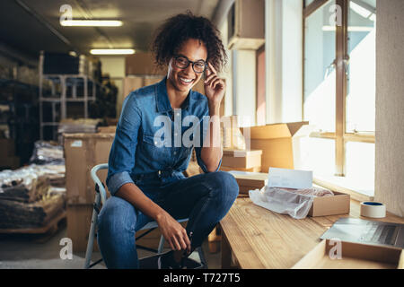 Confident young businesswoman working at online business store. Small business owner at her work desk. Stock Photo