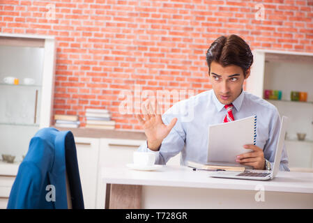 Young handsome employee working in the office Stock Photo