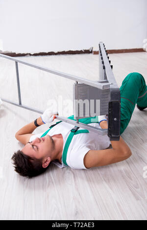 Young worker falling from the ladder Stock Photo