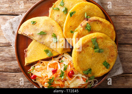 Traditional Latin American pupusas served with curtido closeup on a plate on the table. Horizontal top view from above