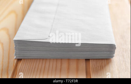 Stack of white envelopes on wooden table. Mail service Stock Photo