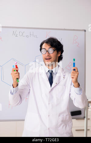 Young funny chemist in front of white board Stock Photo