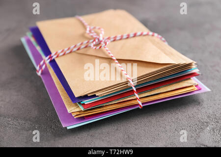 Stack of colorful envelopes on grey background. Mail service Stock Photo