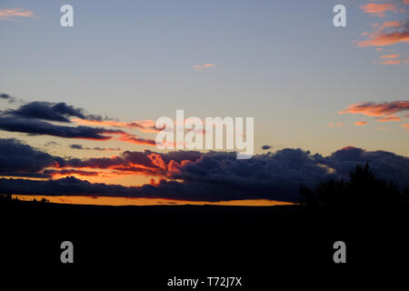 Sun setting behind clouds over a Yorkshire moorland landscape Stock Photo
