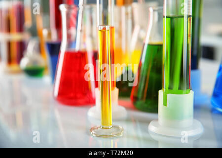 Different laboratory glassware with colorful liquids on table, closeup Stock Photo