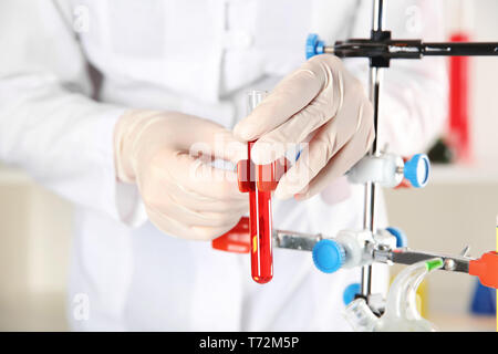 Laboratory assistant with test tube and stand, closeup Stock Photo