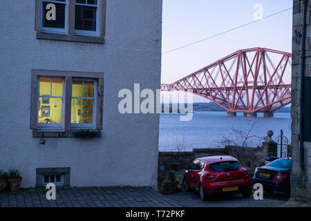 Evening view of a house in South Queensferry and the Forth Rail Bridge over the Firth of Forth, near Edinburgh, Scotland Stock Photo