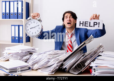 Young businessman employee unhappy with excessive work Stock Photo