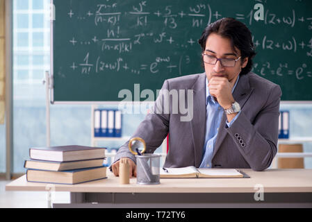 Young handsome math teacher in classroom Stock Photo