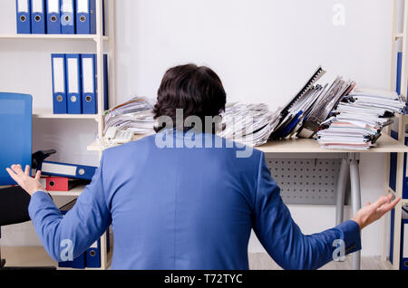 Young businessman employee unhappy with excessive work Stock Photo