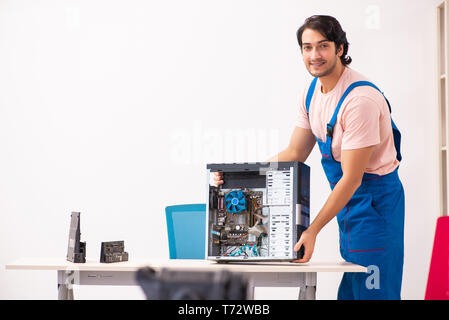 Young male contractor repairing computer Stock Photo