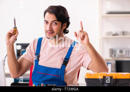 Young male contractor repairing computer Stock Photo