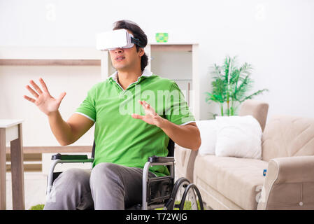 Young handsome man in wheelchair at home Stock Photo
