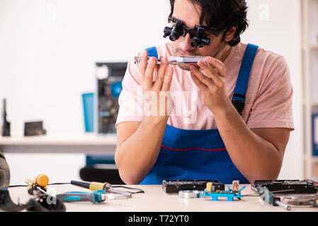 Young male contractor repairing computer Stock Photo