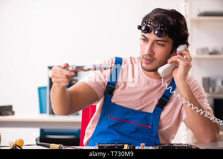 Young male contractor repairing computer Stock Photo