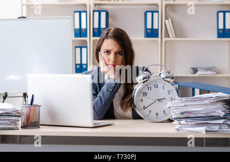 Beautiful female employee unhappy with excessive work Stock Photo