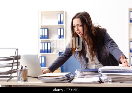 Young female employee unhappy with excessive work Stock Photo