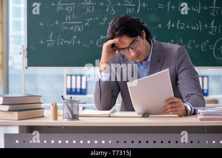 Young handsome math teacher in classroom Stock Photo