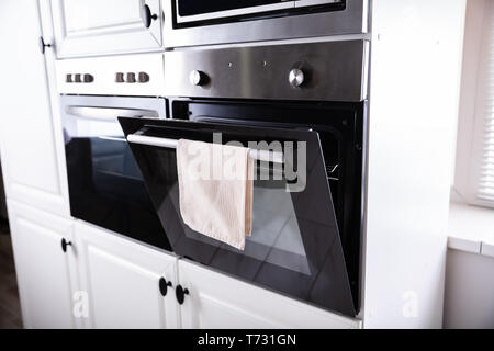 Opened New Electric Oven With Napkin Hanging On It Stock Photo