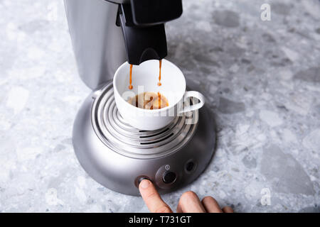 Close-up Of Person's Hand Pressing The Button On A Coffee Maker Taking Coffee Stock Photo