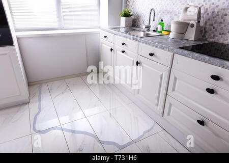 Close-up Of Spilled Water On Kitchen Floor At Home Stock Photo