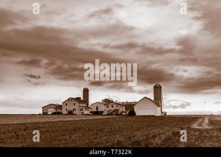 Sepia picture of an old-fashioned Amish farm house with silos in rural Pennsylvania, Lancaster County, PA, USA Stock Photo