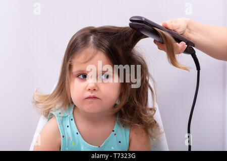 Mother Straightening Hair With Straightener To Her Daughter Stock Photo -  Alamy