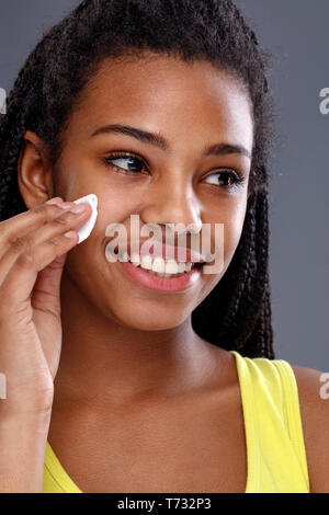 Young African girl cleaning make up from skin Stock Photo
