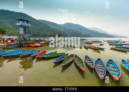 Amazing view on Phewa Lake. colorful boats stop at queued a midday 28-04-2019.in mid ground watch Tower and background green hills.Pokhara Nepal Stock Photo