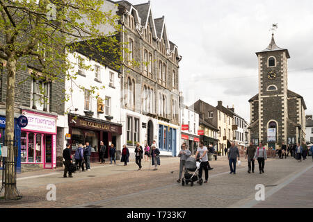 Couple walking pushing buggy in Keswick town centre, Cumbria, England, UK Stock Photo