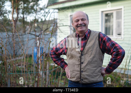 Elderly man in vest on the background of the house in the village Stock Photo
