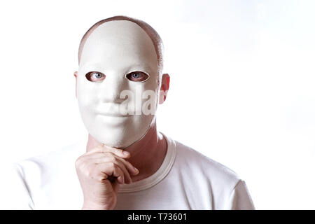 brutal bald man covers his face with mask on white background Stock Photo