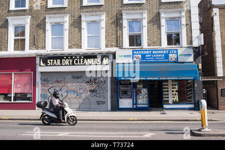 Hackney, London, England, UK - April 2019: Street with local convenience store off licence and cleaners shop in Amhurst road, Hackney, East London Stock Photo
