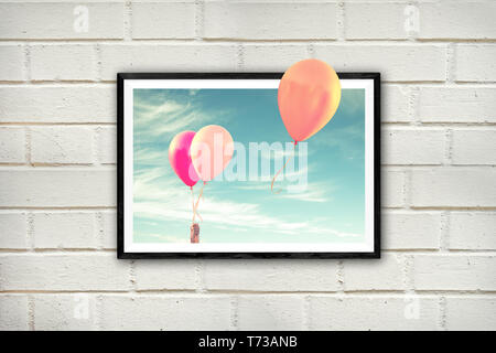Frame with air balloons on a white brick wall, thinking outside the box concept Stock Photo